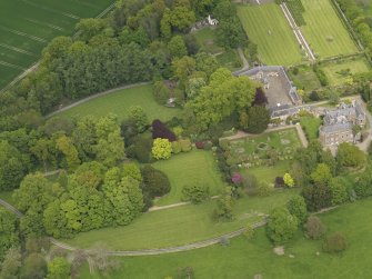 Oblique aerial view of the tower house with the gardens and stables adjacent, taken from the SSW.