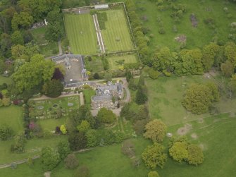 Oblique aerial view of the tower house with the gardens and stables adjacent, taken from the S.