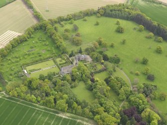 General oblique aerial view of the tower house with the gardens and stables adjacent, taken from the  NW.