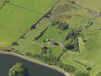 Oblique aerial view centred on the tower house with the remains of the motte (earthworks) adjacent, taken from the SSE.