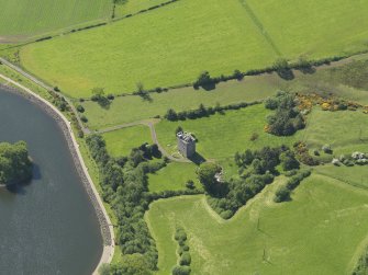 Oblique aerial view centred on the tower house with the remains of the motte (earthworks) adjacent, taken from the E.