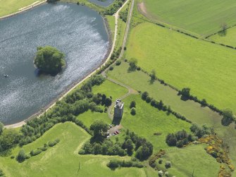 Oblique aerial view centred on the tower house with the remains of the motte (earthworks) adjacent, taken from the NE.