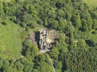 Oblique aerial view centred on the remains of the country house, taken from the NW.