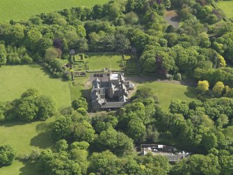 Oblique aerial view centred on the house with the terraced garden adjacent, taken from the N.