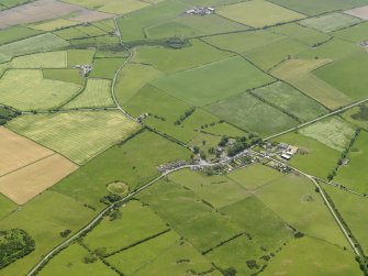 General oblique aerial view centred on the village with the remains of the motte adjacent, taken from the NNW.