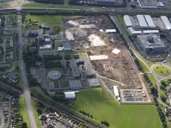 Oblique aerial view centred on St Augustine RC High and Forrester Secondary schools and construction site of new schools, taken from the N.