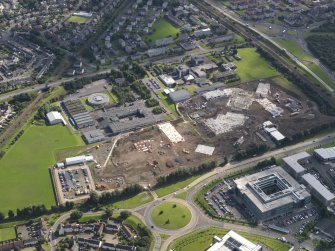 Oblique aerial view centred on construction site of new St Augustines RC High and Forrester Secondary schools, with original schools to E, taken from the WNW.