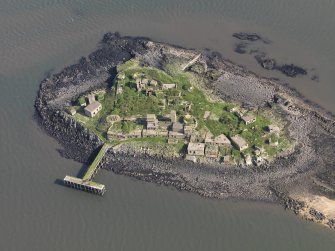 Oblique aerial view of Inchmickery centred on the 20th century military remains, taken from the SW.