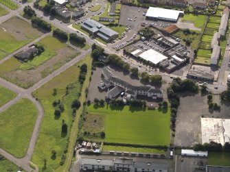 Oblique aerial view centred on St Francis' RC primary school, taken from the NNW.