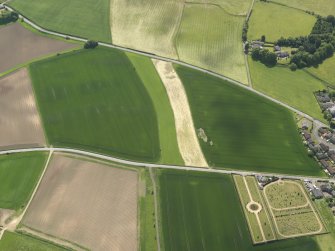 General oblique aerial view centred on the field boundaries with the cemetery adjacent, taken from the N.