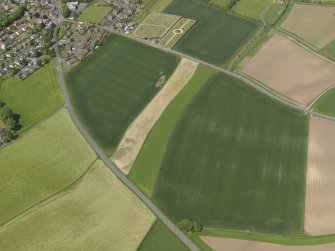 General oblique aerial view centred on the field boundaries with the cemetery adjacent, taken from the SE.