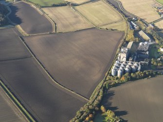 Oblique aerial view of the soilmarks of the fort with the Pentcaitland maltings adjacent, taken from the ESE.