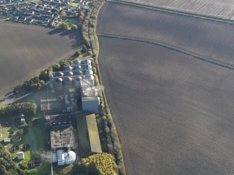 Oblique aerial view of the soilmarks of the fort with the Pentcaitland maltings adjacent, taken from the NW.