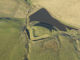Oblique aerial view of the remains of Green Castle fort and rig, taken from the SSE.