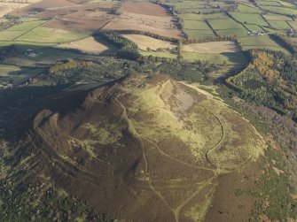 Oblique aerial view of the remains of the fort and plantation bank on Eildon Hill North, taken from the SW.
