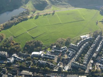 Oblique aerial view of the slight earthworks on the site of Clockmill House, Holyrood Park, taken from the NNE.