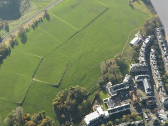 Oblique aerial view of the slight earthworks on the site of Clockmill House, Holyrood Park, taken from the NE.