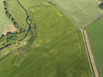 Oblique aerial view centred on the cropmarks of the unenclosed settlement, enclosure and rig, taken from the WNW.