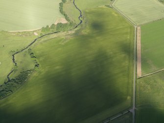 Oblique aerial view centred on the cropmarks of the unenclosed settlement, enclosure and rig, taken from the NW.