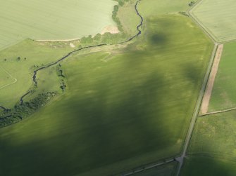 Oblique aerial view centred on the cropmarks of the unenclosed settlement, enclosure and rig, taken from the NW.