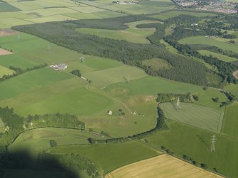 General oblique aerial view of the country house and the remains of the motte and bailey castle, with Hirsel Law beyond, taken from the NW.