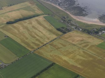 Oblique aerial view centred on the cropmarks of the rig and the village of East Haven, taken from the W.