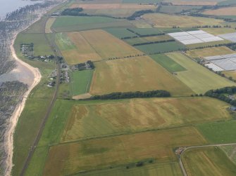 General oblique aerial view of the cropmarks of the rig and ring ditch between Hatton Country House and East Haven, taken from the E.