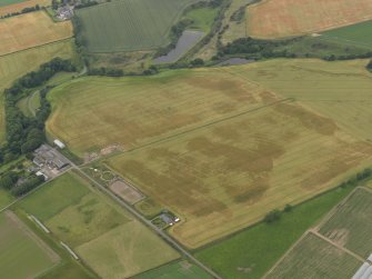 Oblique aerial view centred on the cropmarks of the rig, pits and barrows on Craigmill Farm, taken from the E.