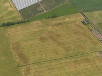 Oblique aerial view centred on the cropmarks of the rig, pits and barrows on Craigmill Farm, taken from the WSW.