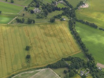 Oblique aerial view of the cropmarks of the buildings and rig and furrow with Lathrisk House adjacent, taken from the NNW.