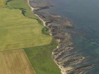 Oblique aerial view centred on the cropmarks of the fort at Randerston, taken from the SE.