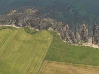 Oblique aerial view centred on the cropmarks of the fort at Randerston, taken from the SW.