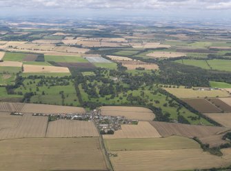 General oblique aerial view centred on Balcarres House and policies with Colinsburgh village adjacent, taken from the S.