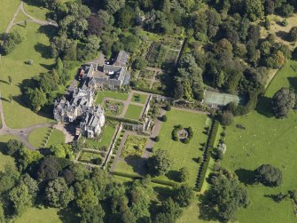 Oblique aerial view centred on the house with the gardens adjacent, taken from the SW.