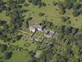 Oblique aerial view centred on the house with the gardens adjacent, taken from the SE.