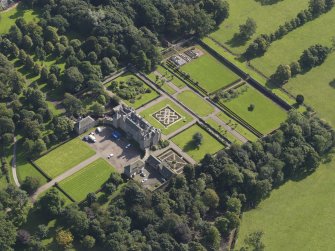 Oblique aerial view centred on the house with the gardens adjacent, taken from the NW.