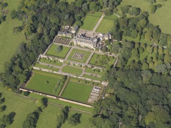 Oblique aerial view centred on the house with the gardens adjacent, taken from the SE.