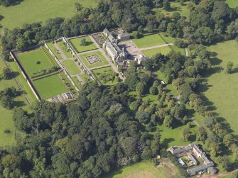 Oblique aerial view centred on the house with the gardens adjacent, taken from the E.