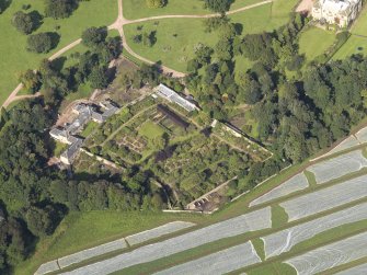 Oblique aerial view centred on the walled garden with the stables adjacent, taken from the SE.