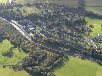 Oblique aerial view centred on the mills with the cottages adjacent, taken from the NW.