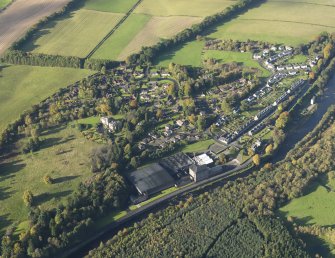 Oblique aerial view centred on the mills with the cottages adjacent, taken from the SE.