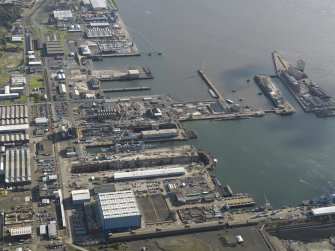 Oblique aerial view centred on the dry docks with the main basin adjacent, taken from the W.