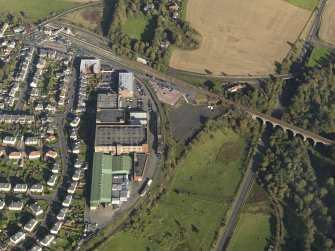 Oblique aerial view centred on the distillery with the railway viaduct adjacent, taken from the W.