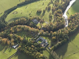 Oblique aerial view centred on the house with the stables adjacent, taken from the WNW.