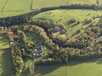 Oblique aerial view centred on the house with the stables adjacent, taken from the SW.
