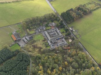 Oblique aerial view centred on the farmstead with the sawmill adjacent, taken from the NE.