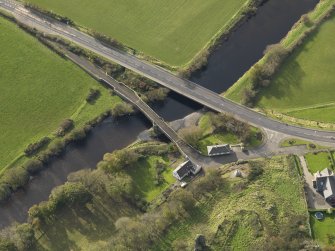 Oblique aerial view centred on the bridges with the remains of the castle adjacent, taken from the NE.