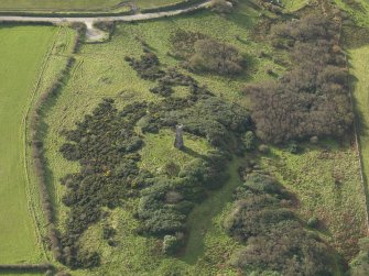 Oblique aerial view centred on the remains of the fort with the monument adjacent, taken from the NE.