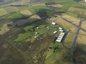 Oblique aerial view centred on the technical site with the airfield adjacent, taken from the ESE.