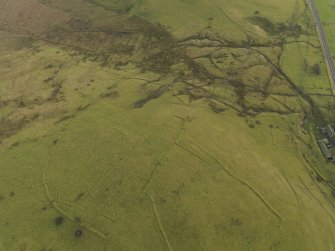 Oblique aerial view centred on the the remains of the enclosures with the cultivation remains adjacent, taken from the NW.